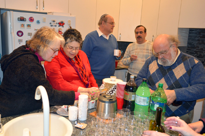 People gathered in the Raus' kitchen for appetizers and desserts.